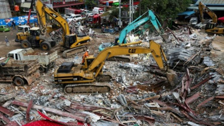 Des secouristes déblaient les décombres d'un immeuble en construction qui s'est effondré à Sihanoukville le 23 juin 2019