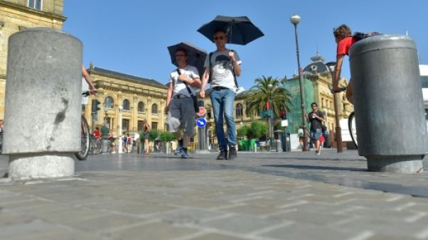 Deux hommes se protègent du soleil à Saint-Sebastien (Espagne) le 26 juin 2019 Deux hommes se protègent du soleil à Saint-Sebastien (Espagne) le 26 juin 2019
