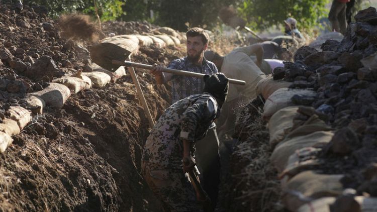 متطوعون سوريون يحفرون الخنادق ويطهون الطعام في الحرب مع الأسد