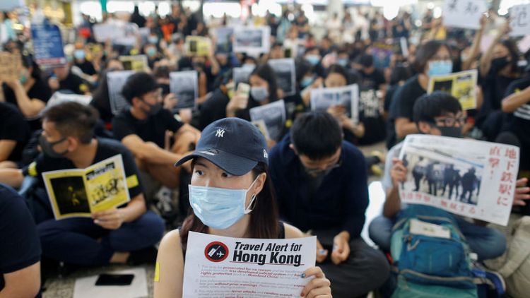 المحتجون يجتاحون مطار هونج كونج وشركات العقارات تدعو للهدوء