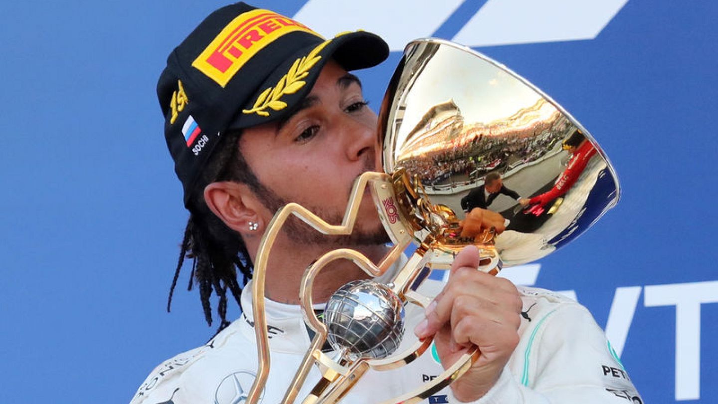 Lewis Hamilton kisses his trophy on the podium