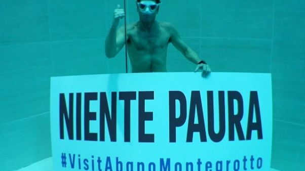 Pellizzari con cartello 'niente paura' Pellizzari con cartello 'niente paura'