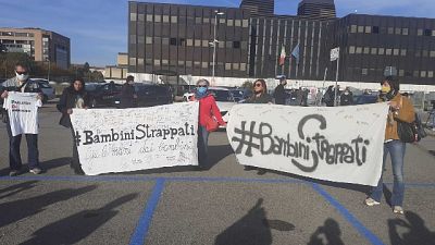 Fuori dal tribunale alcuni manifestanti, magliette e striscioni Fuori dal tribunale alcuni manifestanti, magliette e striscioni