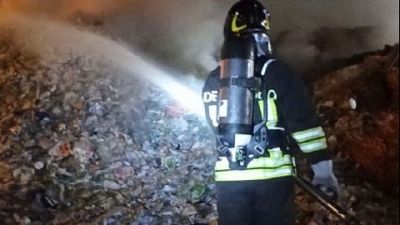 A fuoco un compattatore e cataste di cartone A fuoco un compattatore e cataste di cartone