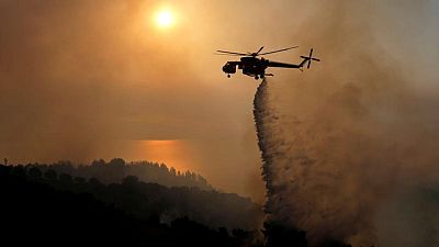 La gente huye de sus casas mientras el fuego arde cerca de zona industrial de Atenas