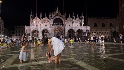 Tourists wade through Venice square hit by unseasonal flood