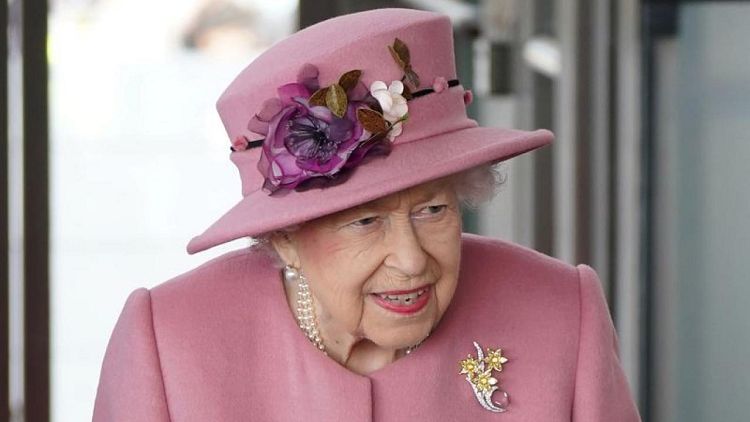 Queen Elizabeth shown standing and smiling at Windsor Castle