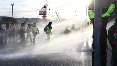 Polizia con idranti su manifestanti seduti a terra Polizia con idranti su manifestanti seduti a terra