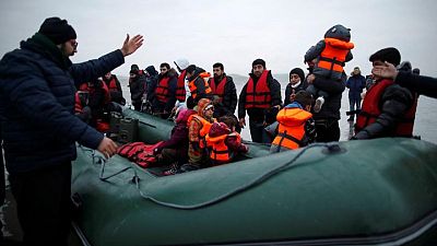 In the cold sea, migrants cast off for England from a French beach