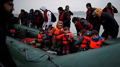 Inmigrantes zarpan en el frío mar hacia Inglaterra desde una playa francesa