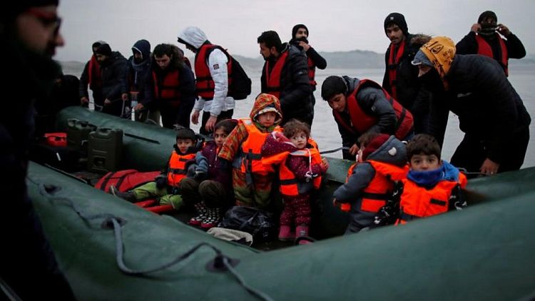 Inmigrantes zarpan en el frío mar hacia Inglaterra desde una playa francesa