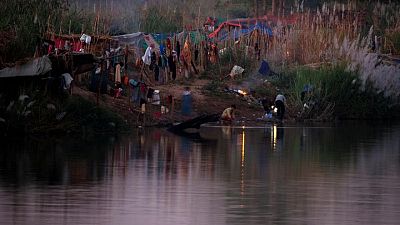 Fleeing violence in Myanmar, thousands camp along Thai border river