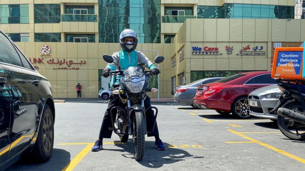 عامل لتوصيل طلبات الطعام على دراجة نارية في مدينة دبي بالإمارات العربية المتحدة.