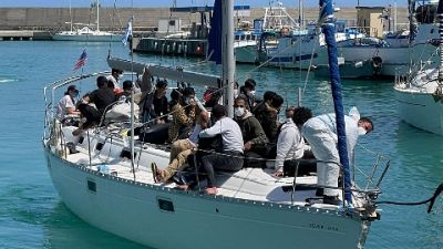 Arrivati su barca a vela che si è arenata sulla spiaggia Arrivati su barca a vela che si è arenata sulla spiaggia