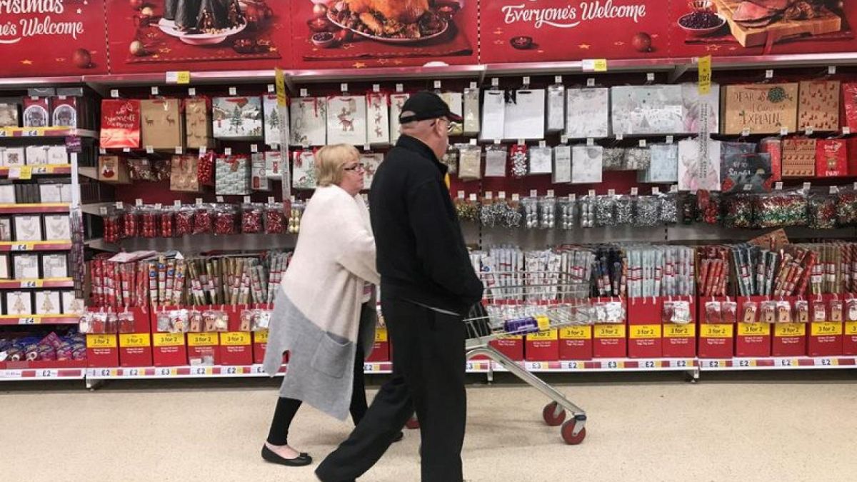 A couple tour supermarket shelves during Christmas