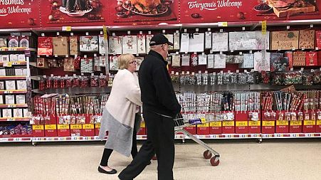 A couple tour supermarket shelves during Christmas