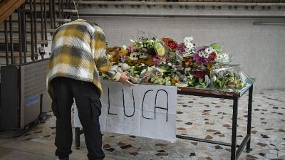 Sotto un cartellone con la scritta 'Luca riposa in pace' Sotto un cartellone con la scritta 'Luca riposa in pace'
