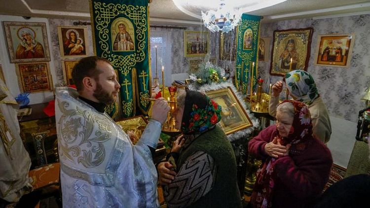 سكان بلدة أوكرانية محتلة يحتفلون بعيد الميلاد في منزل بعد قصف كنيستهم